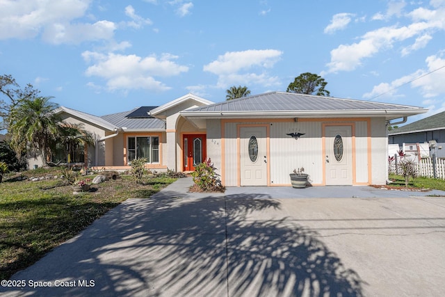 view of front of property with metal roof and fence