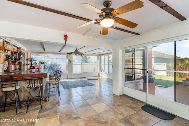 sunroom featuring a ceiling fan