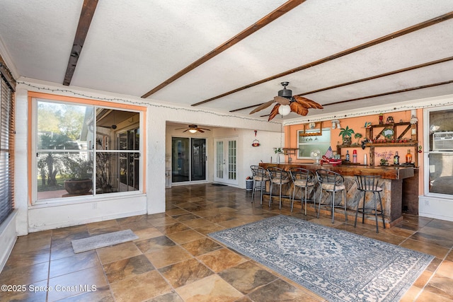 interior space with a textured ceiling and beam ceiling