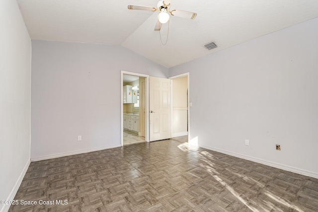 empty room featuring baseboards, visible vents, vaulted ceiling, and a ceiling fan