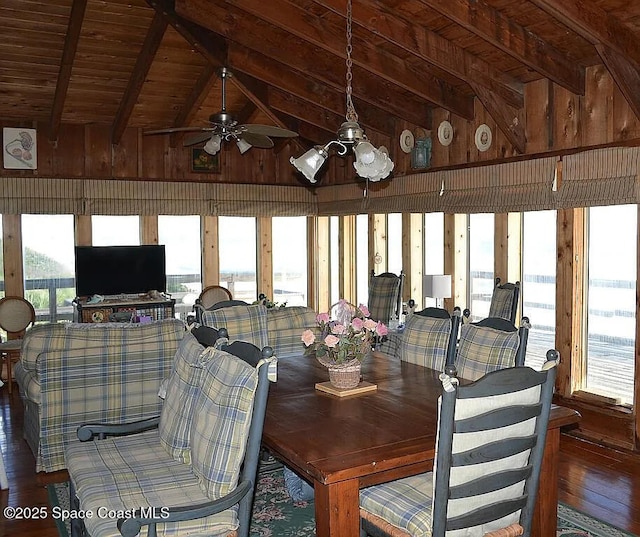 dining room featuring vaulted ceiling with beams, wooden ceiling, wood walls, and ceiling fan