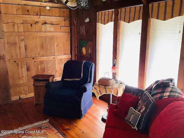 living area with wood walls and wood finished floors