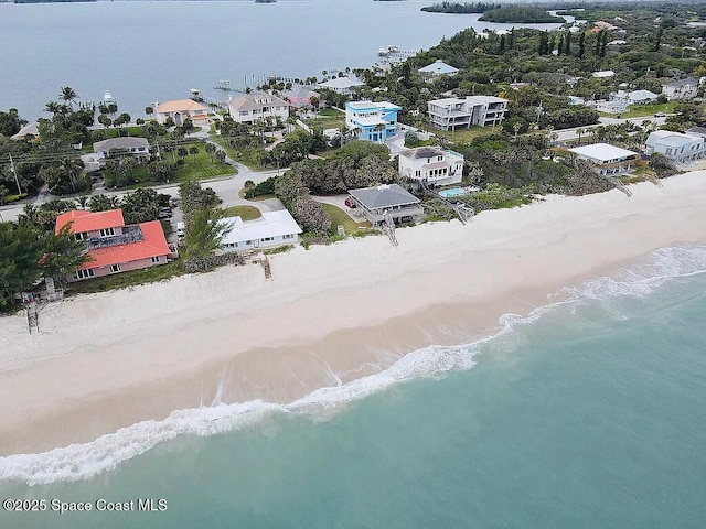 birds eye view of property with a water view and a view of the beach