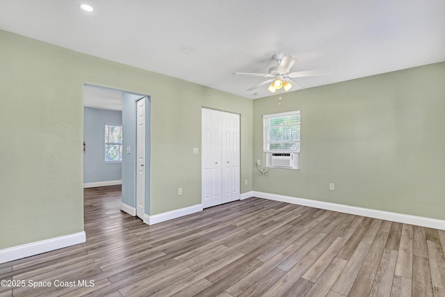 unfurnished bedroom with ceiling fan, a closet, baseboards, and wood finished floors