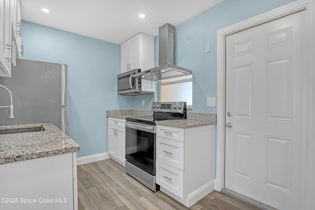 kitchen with stainless steel appliances, baseboards, white cabinets, wall chimney range hood, and wood tiled floor