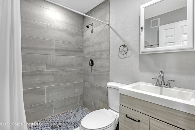 bathroom featuring visible vents, a textured wall, and toilet