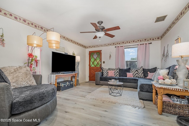 living room featuring visible vents, ceiling fan, and wood finished floors