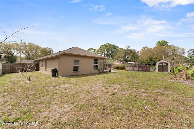 view of yard featuring a shed, a fenced backyard, and an outdoor structure