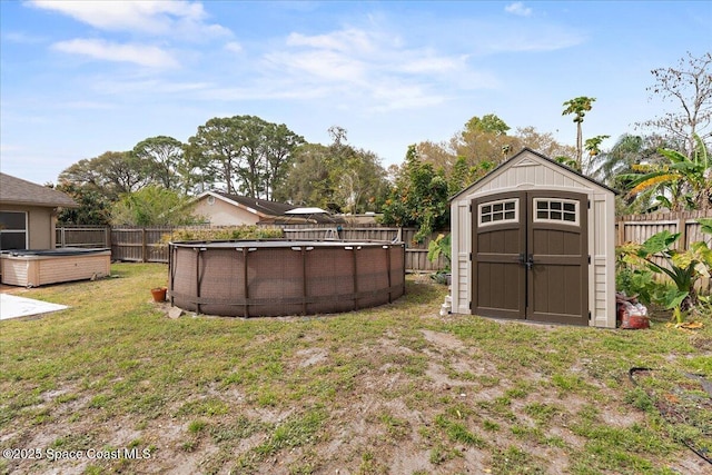 view of yard with a fenced backyard, a storage unit, a fenced in pool, and an outdoor structure