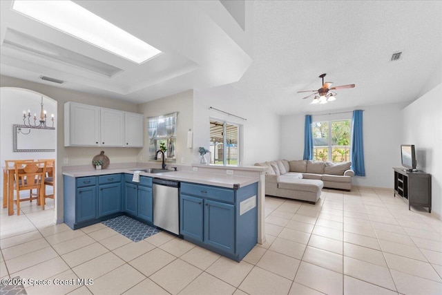 kitchen featuring blue cabinetry, a raised ceiling, visible vents, a sink, and dishwasher