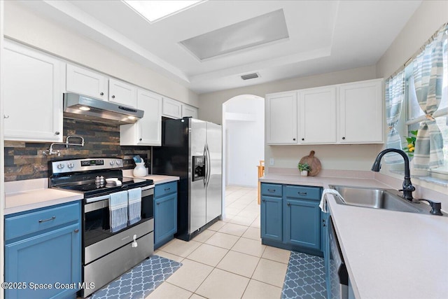 kitchen with stainless steel appliances, blue cabinetry, and under cabinet range hood