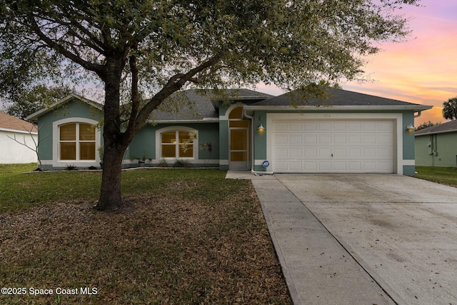 single story home featuring an attached garage, driveway, a front lawn, and stucco siding