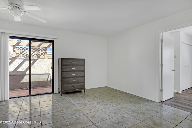 spare room with a ceiling fan, baseboards, and tile patterned floors