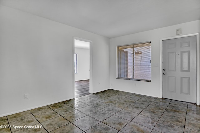 interior space featuring baseboards and tile patterned floors