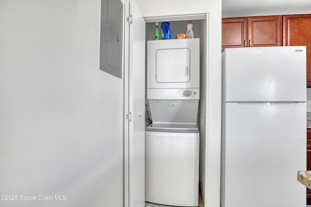 laundry area featuring stacked washer and dryer, laundry area, and electric panel