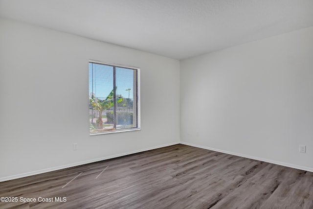 empty room featuring baseboards and wood finished floors