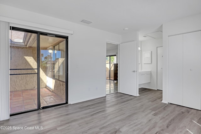 empty room with baseboards, visible vents, and wood finished floors