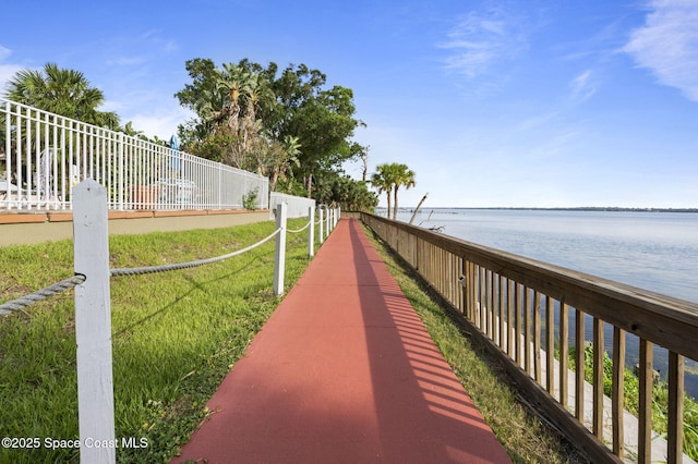 view of community featuring a water view and fence