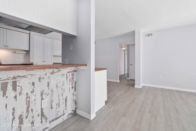 kitchen with visible vents, baseboards, and light wood-style floors