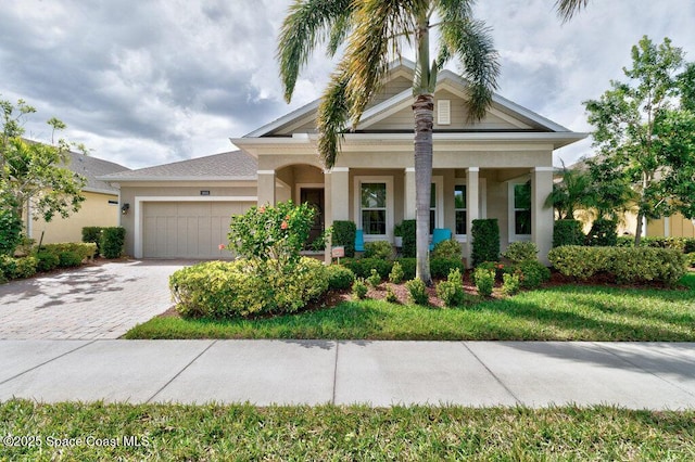 view of front of house with a garage, decorative driveway, and stucco siding