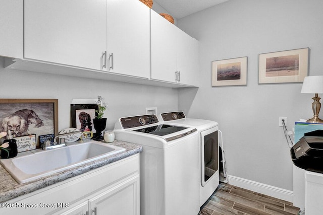 3465 Diamond Leaf Dr, Vero Beach, FL 32966 - clothes washing area featuring separate washer and dryer, a sink, baseboards, cabinet space, and wood tiled floor