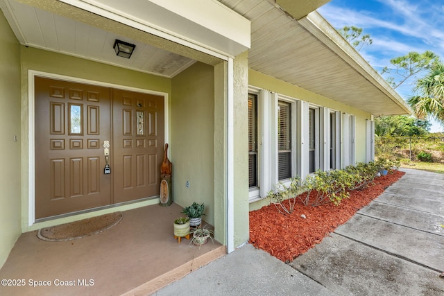 view of exterior entry with stucco siding