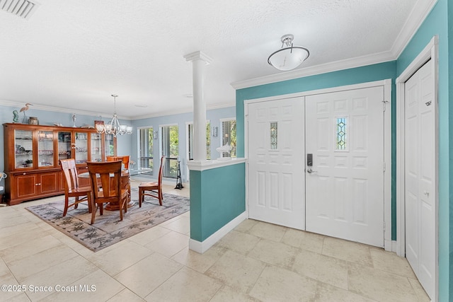 entrance foyer featuring visible vents, an inviting chandelier, crown molding, baseboards, and ornate columns