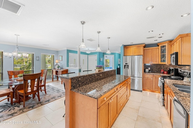 kitchen featuring visible vents, backsplash, a center island, appliances with stainless steel finishes, and glass insert cabinets