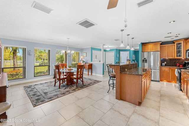 kitchen with brown cabinetry, visible vents, and appliances with stainless steel finishes