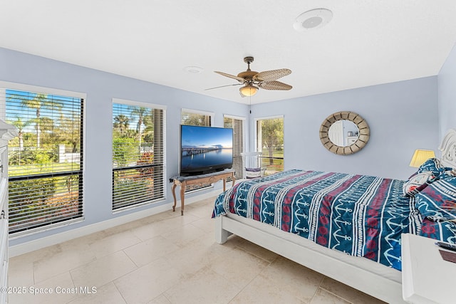 bedroom featuring tile patterned floors, baseboards, and a ceiling fan