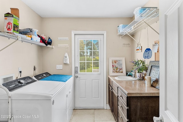 laundry area with a sink, cabinet space, independent washer and dryer, and light tile patterned floors