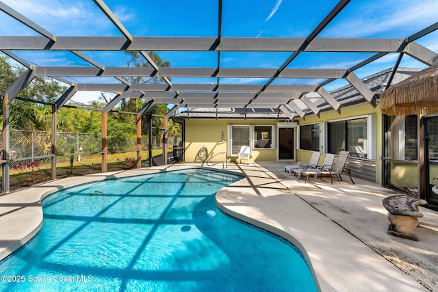 pool featuring glass enclosure and a patio area