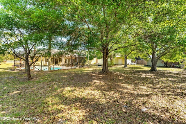 view of yard featuring an outdoor pool and a lanai