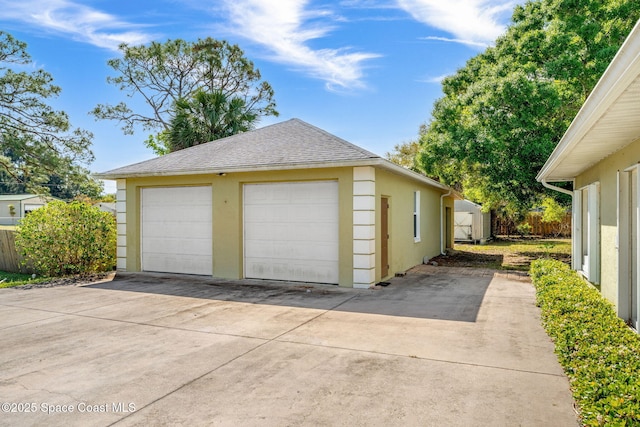 detached garage featuring fence