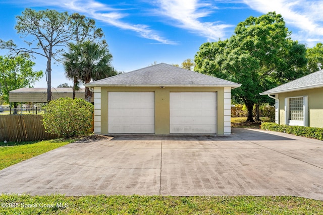 detached garage featuring fence