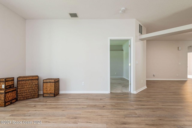 unfurnished room with baseboards, visible vents, and wood finished floors