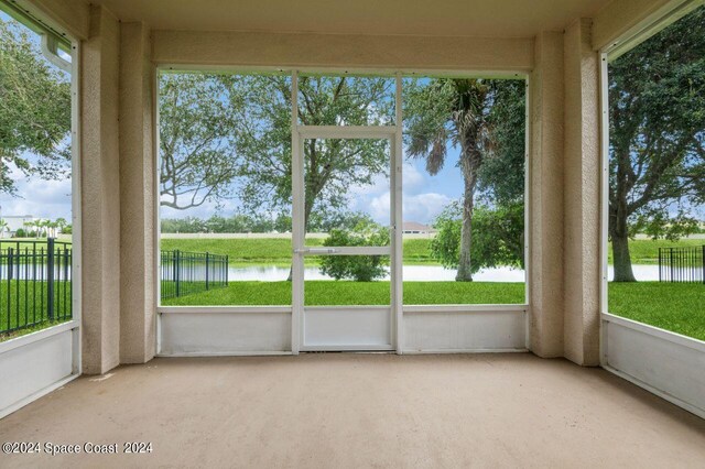 unfurnished sunroom featuring a water view and a healthy amount of sunlight