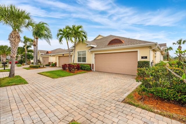 single story home featuring stucco siding, decorative driveway, and a garage