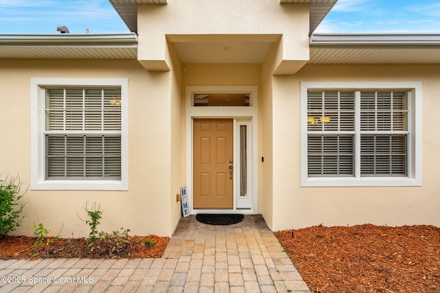 doorway to property featuring stucco siding