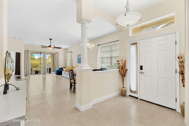 entrance foyer featuring light tile patterned floors, decorative columns, plenty of natural light, and baseboards