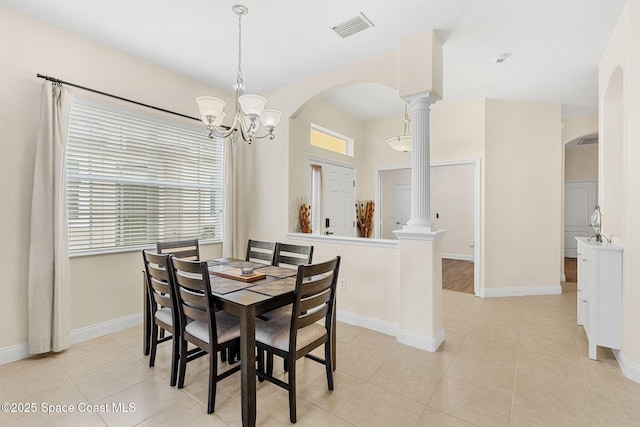 dining space featuring visible vents, arched walkways, a notable chandelier, and ornate columns