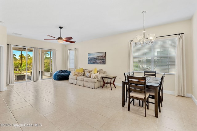 dining room featuring light tile patterned floors, visible vents, ceiling fan with notable chandelier, and baseboards