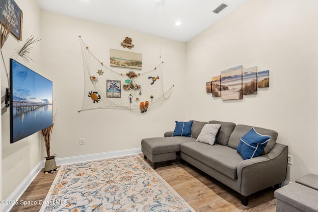 living room featuring recessed lighting, visible vents, baseboards, and wood finished floors