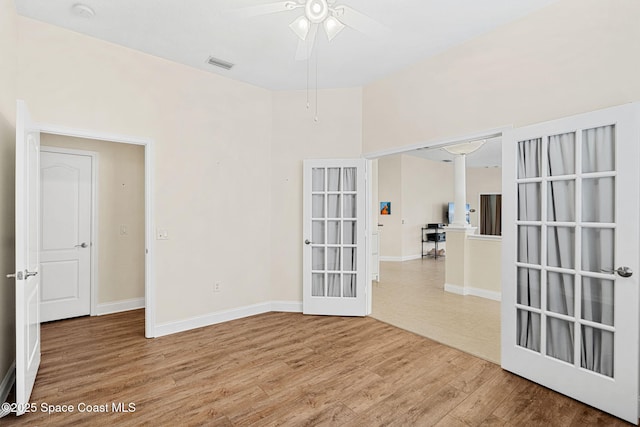 spare room featuring visible vents, baseboards, ceiling fan, french doors, and wood finished floors