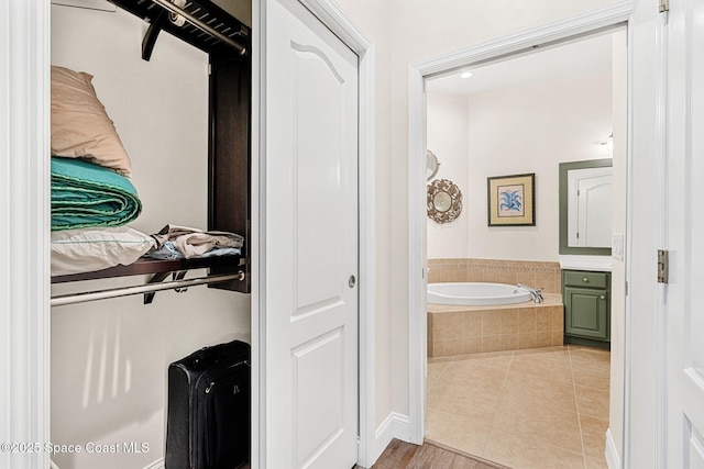 bathroom with tile patterned floors and a bath