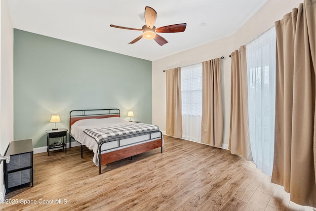 bedroom featuring baseboards, a ceiling fan, and wood finished floors