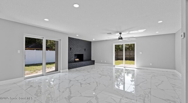 unfurnished living room with a fireplace, marble finish floor, and a wealth of natural light