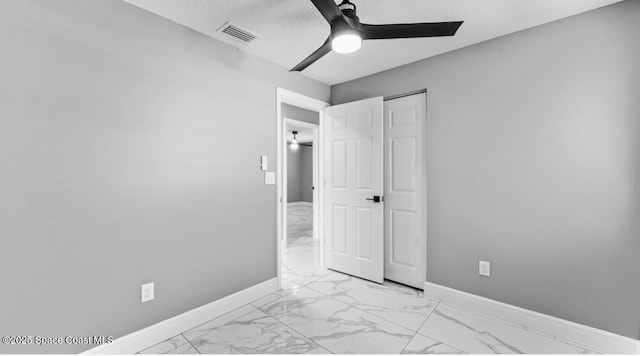 unfurnished bedroom featuring baseboards, visible vents, marble finish floor, and a textured ceiling