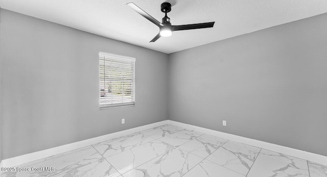 spare room with baseboards, marble finish floor, and ceiling fan