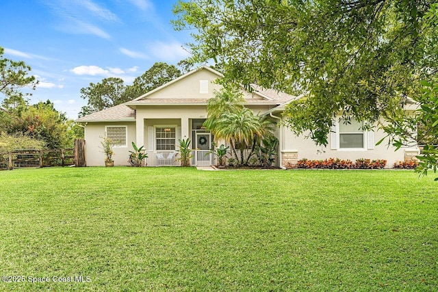 view of front of property featuring covered porch, fence, a front lawn, and stucco siding